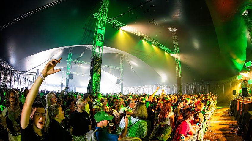 Publiek en trusstorens in de 27,5 m festivaltent