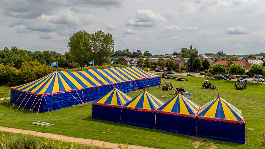 Gezellige feesttent voor dorpsfeest met bezoekers en feestverlichting