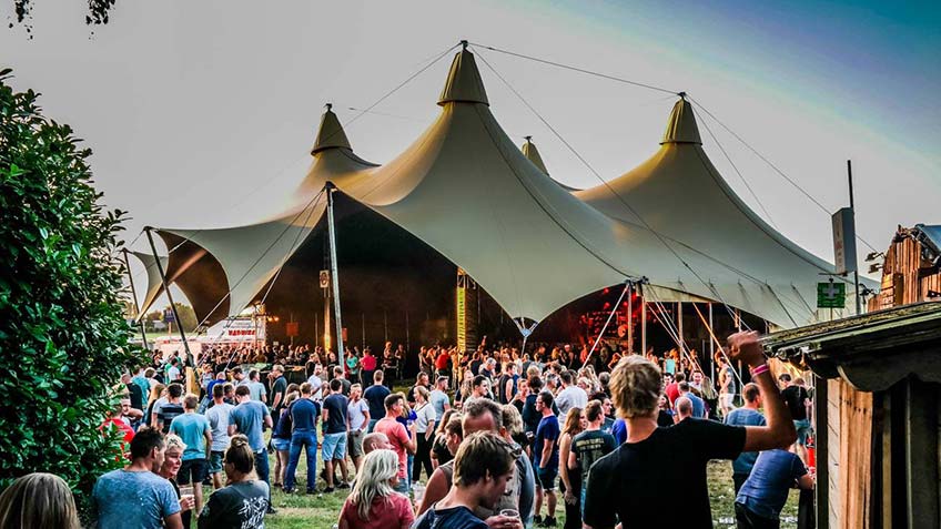 Grote festival feesttent met podium en verlichting voor duizenden bezoekers